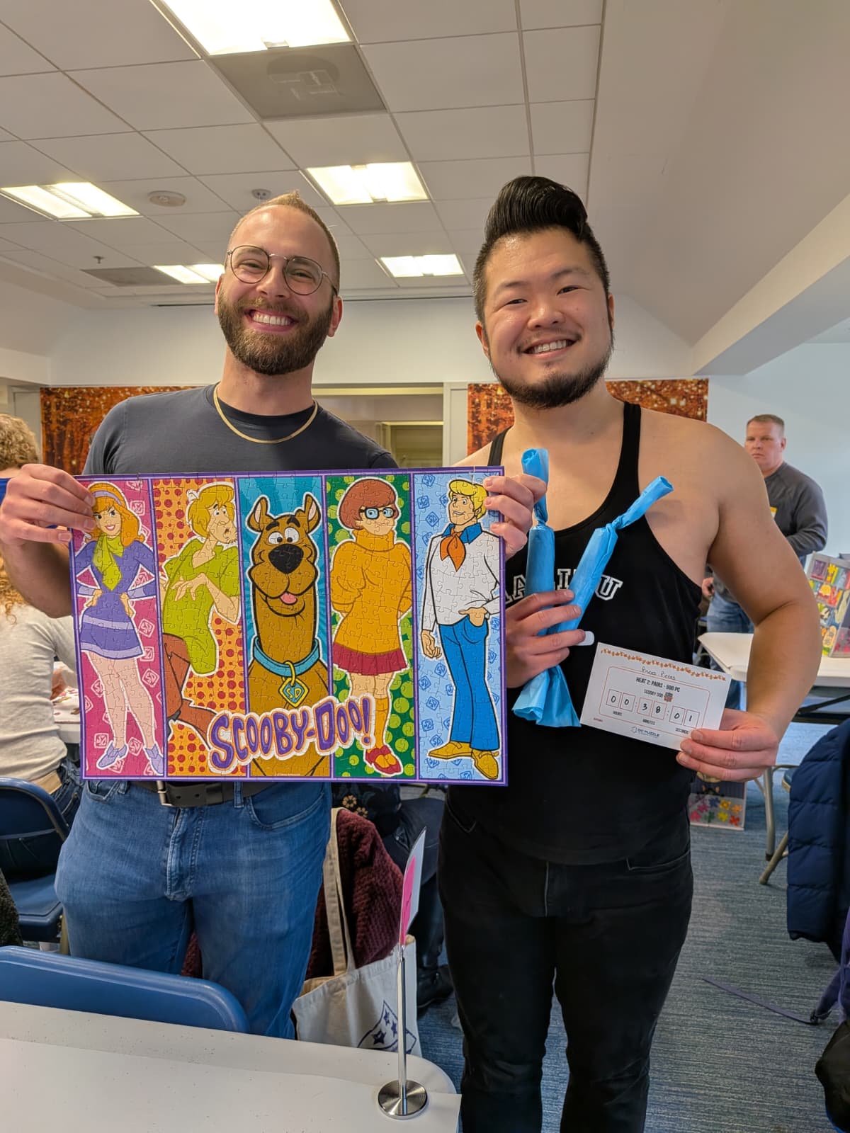 A photo of Andrew and Michael holding up our completed puzzle, Scooby Doo Characters.