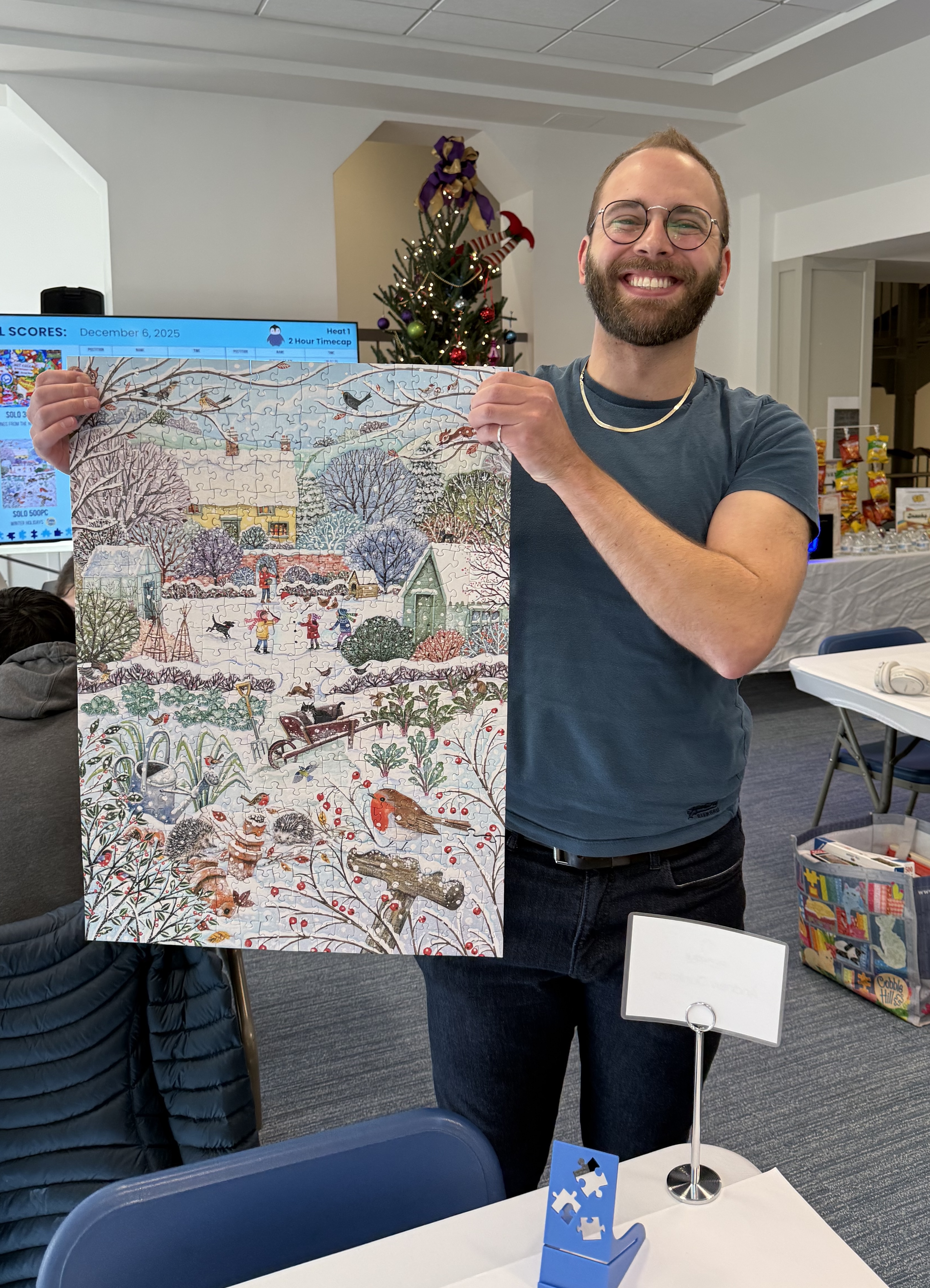 A photo of Andrew holding up my completed puzzle, Snow Day.