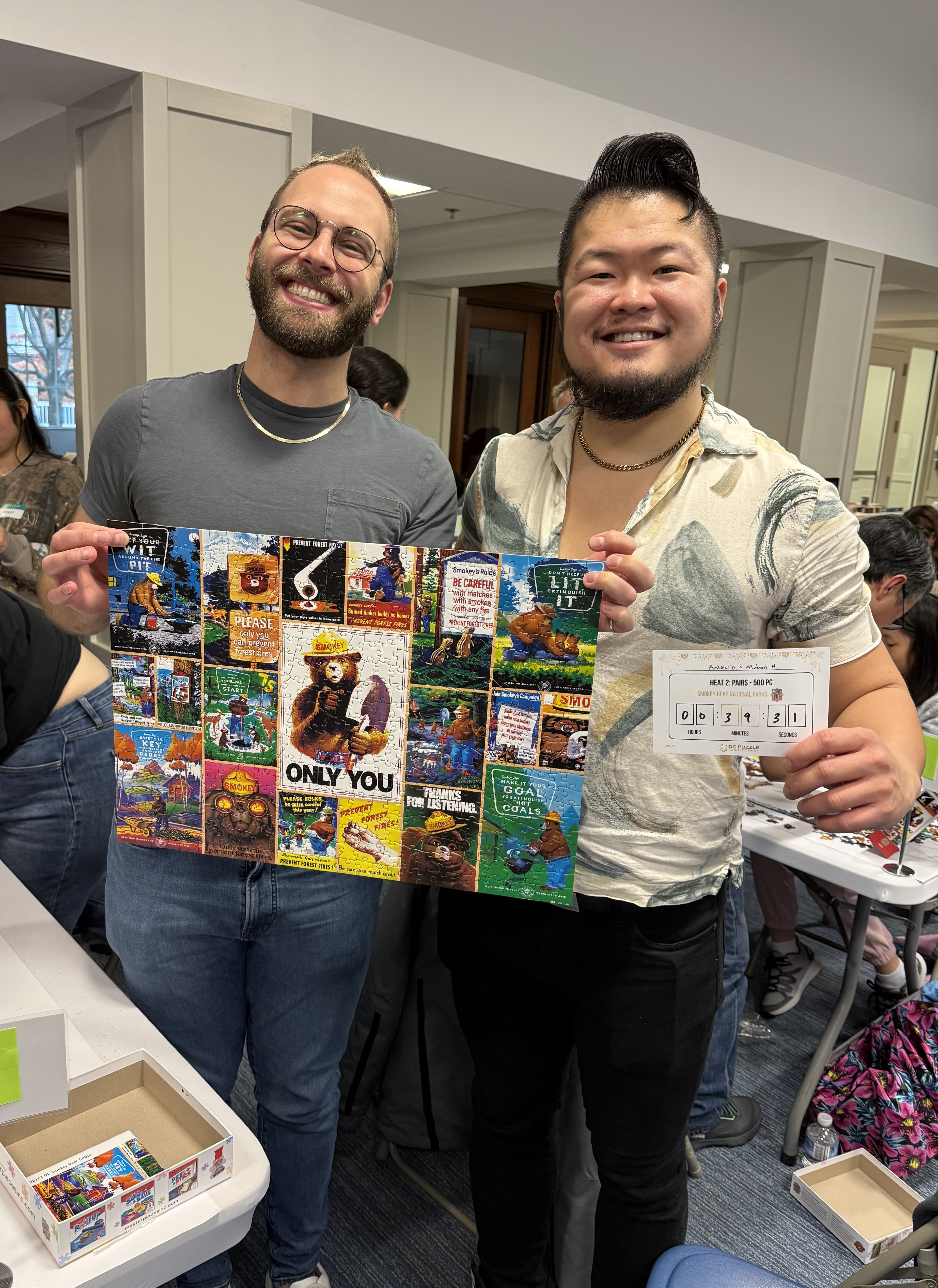 A photo of Andrew and Michael holding up our completed puzzle, Smokey Bear National Parks.