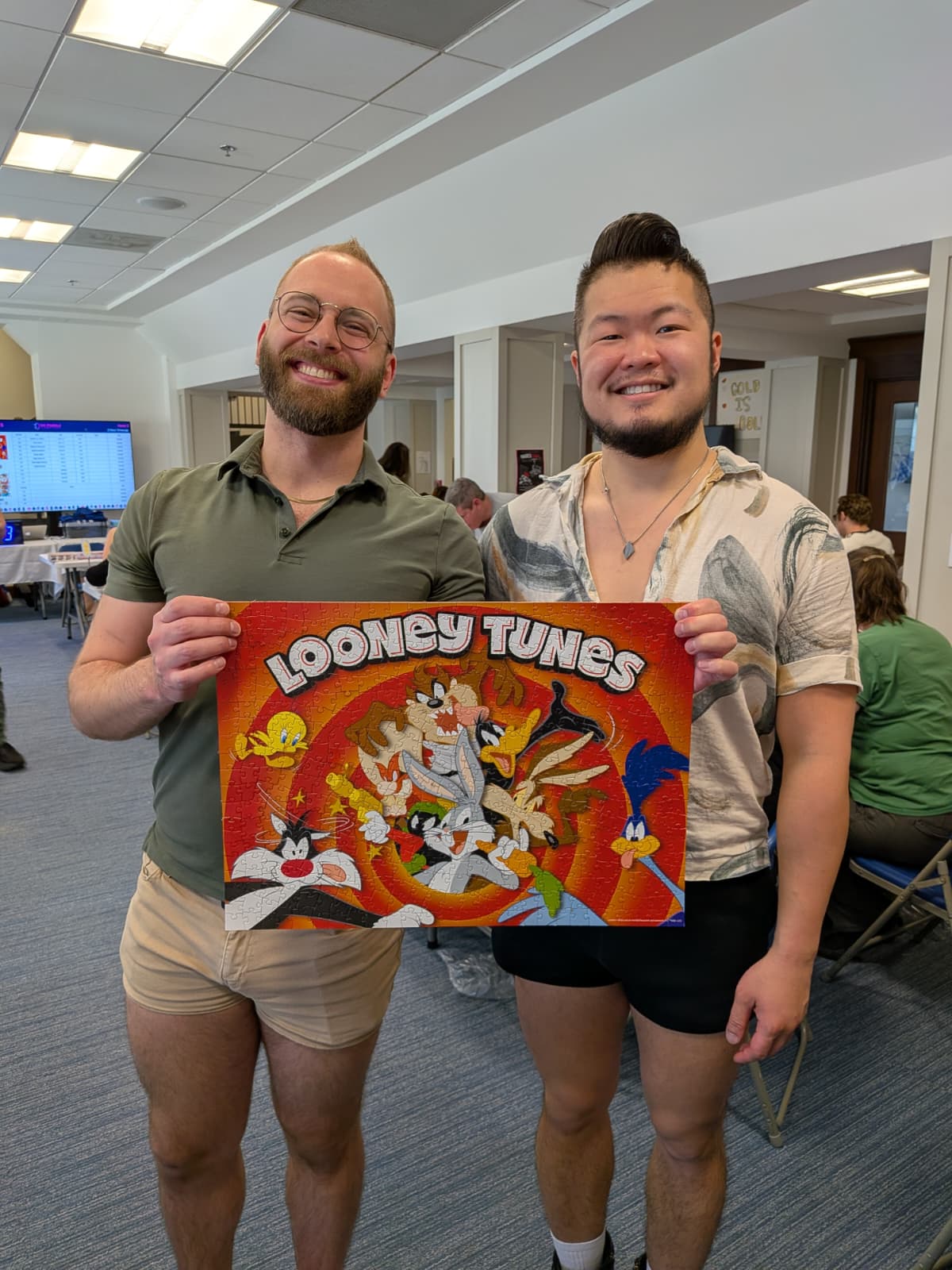 A photo of Andrew and Michael holding their completed puzzle, Looney Tunes.