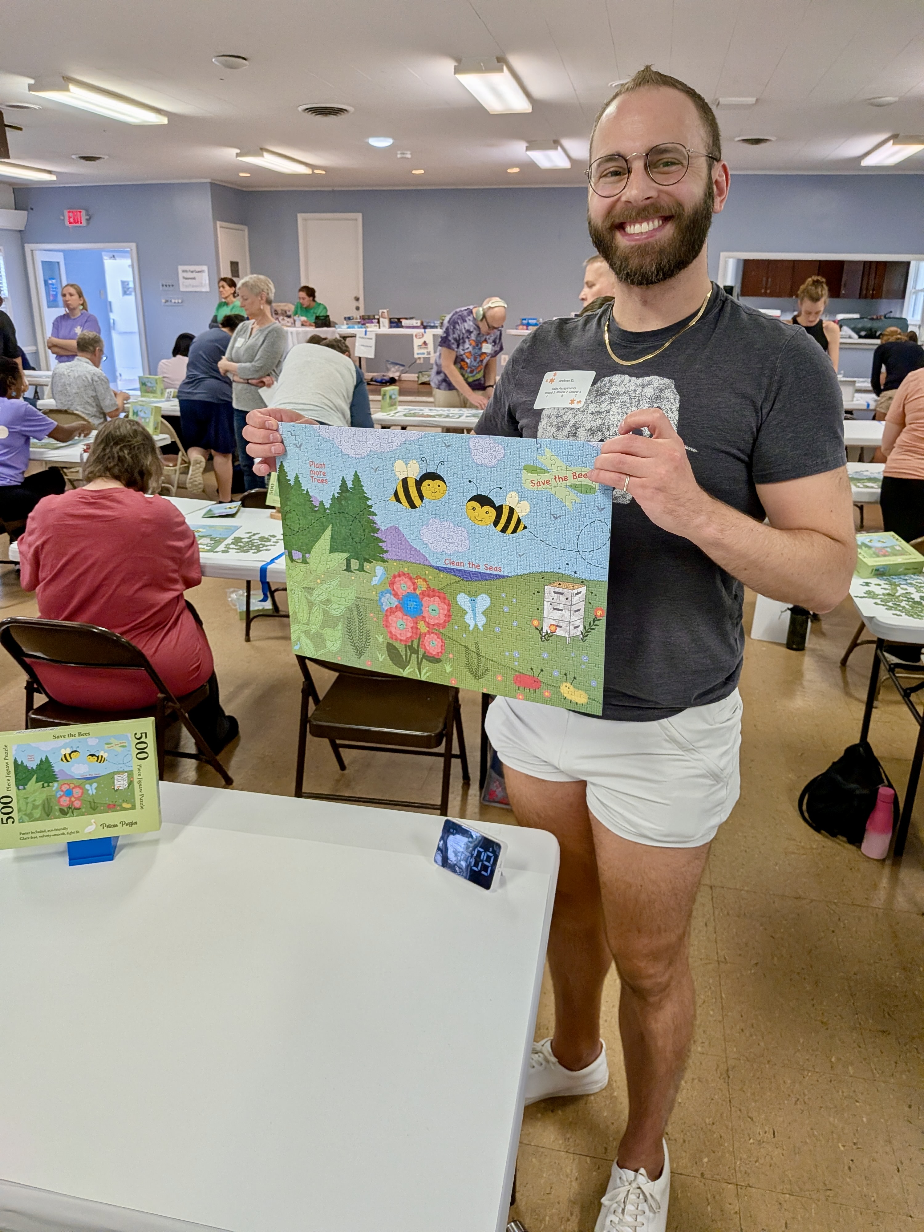 A photo of Andrew holding his completed Save the Bees puzzle.